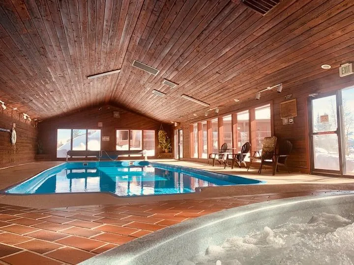 Shared indoor pool and hot tub area with wood ceiling
